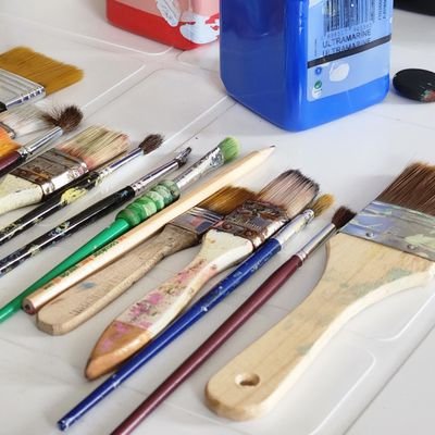 A collection of colorful acrylic paints and brushes on a white surface, perfect for creative projects.