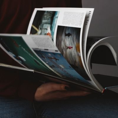 A person flips through a photography book, emphasizing the visuals.