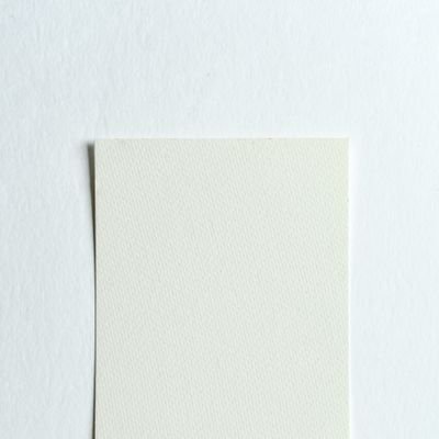 Top view of a white paper sheet on a textured white background, perfect for designs.